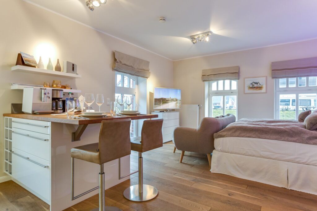 Doppelbett und Küche in Ferienhaus auf Sylt