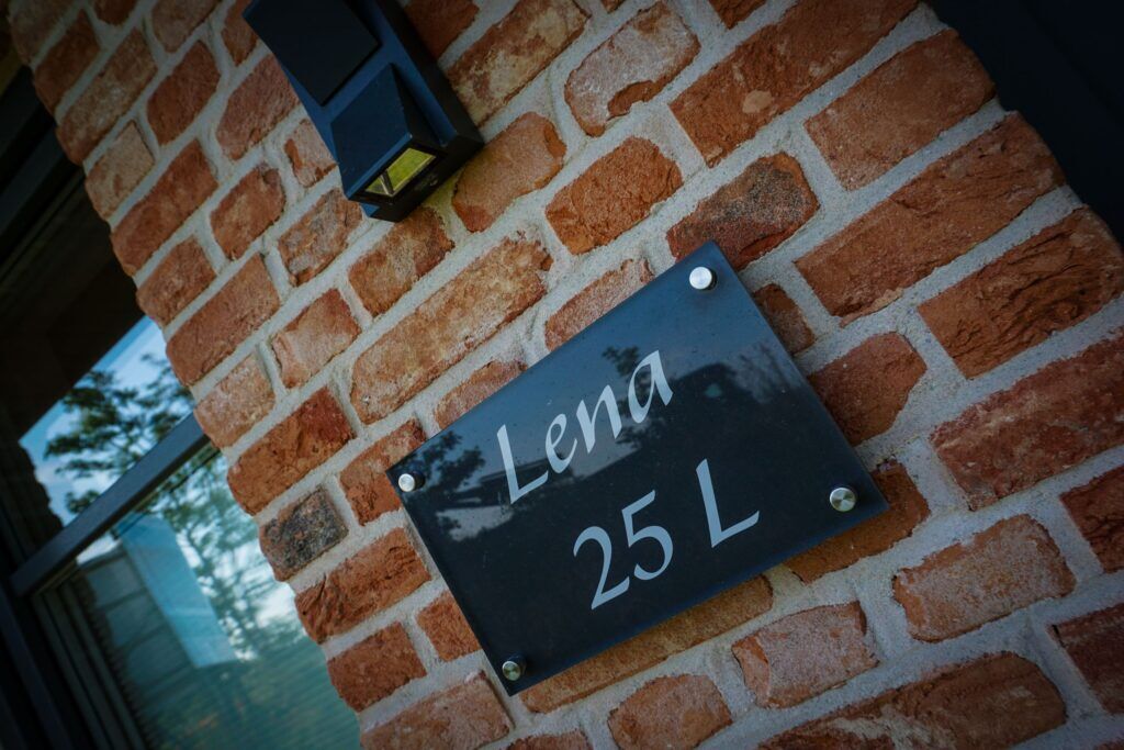 Schild "Lena 25 L" an einem Ferienhaus auf Sylt